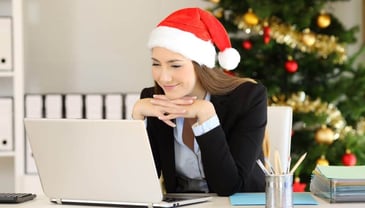 Woman on Christmas hat looking at laptop - Google Analytics Pre holiday Giveaway 